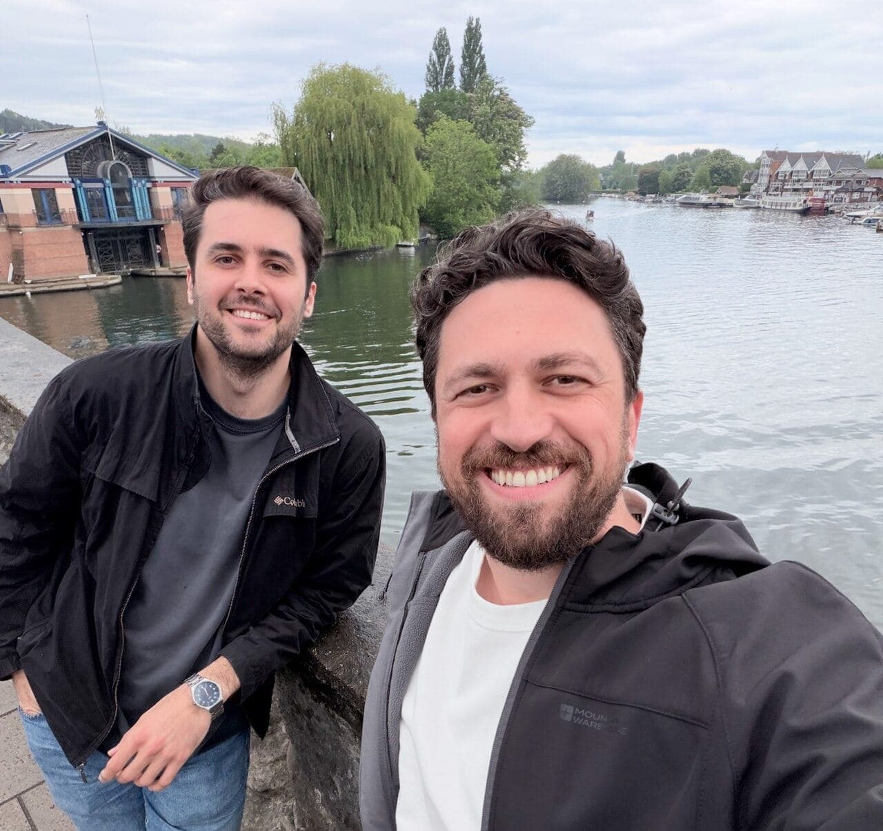 Emre Elbeyoglu and Erkan Efecan beside the Thames on an overcast afternoon