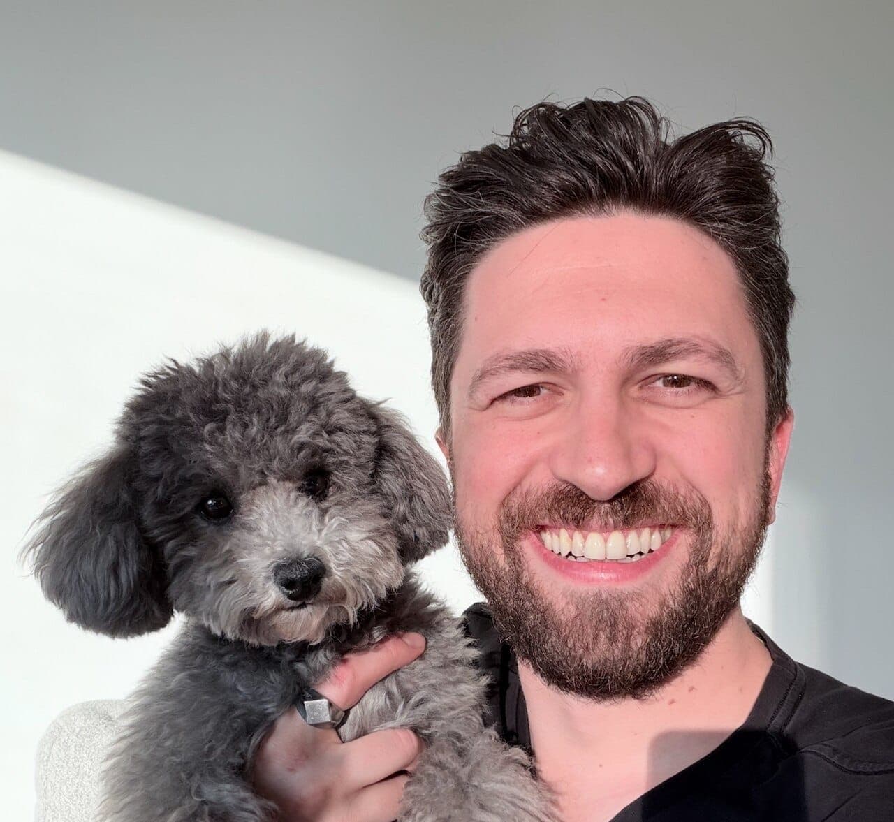 Emre Elbeyoglu holding his silver poodle